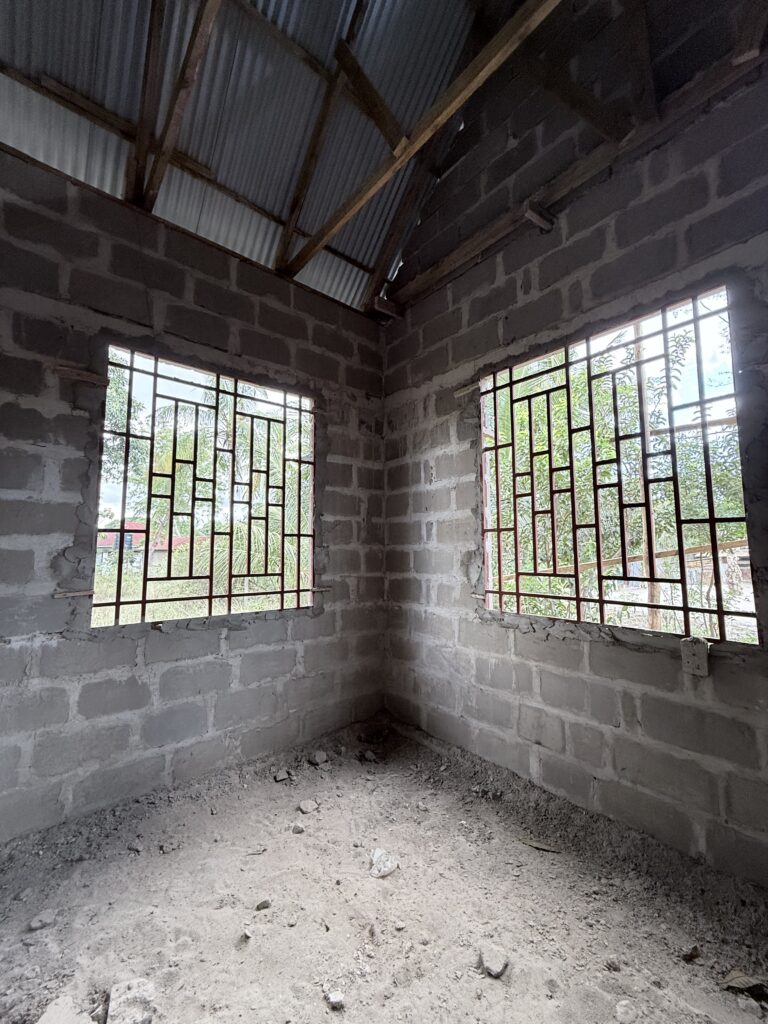 Open window and door frames inside the unfinished Kiromo medical clinic.