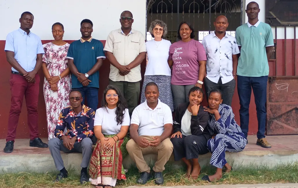 Teachers, staff, local partners, and an AFAC representative gather for a group photograph outside Lawrence Academy in Tanzania, highlighting the people involved in the school's ongoing work.